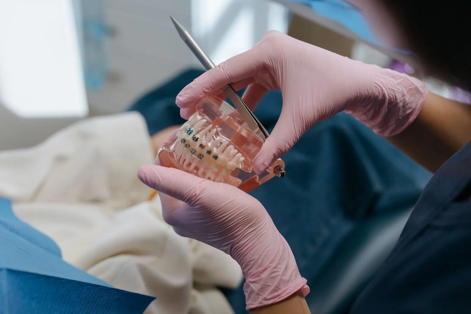 Modelo dental con brackets de ortodoncia sujetado por un profesional