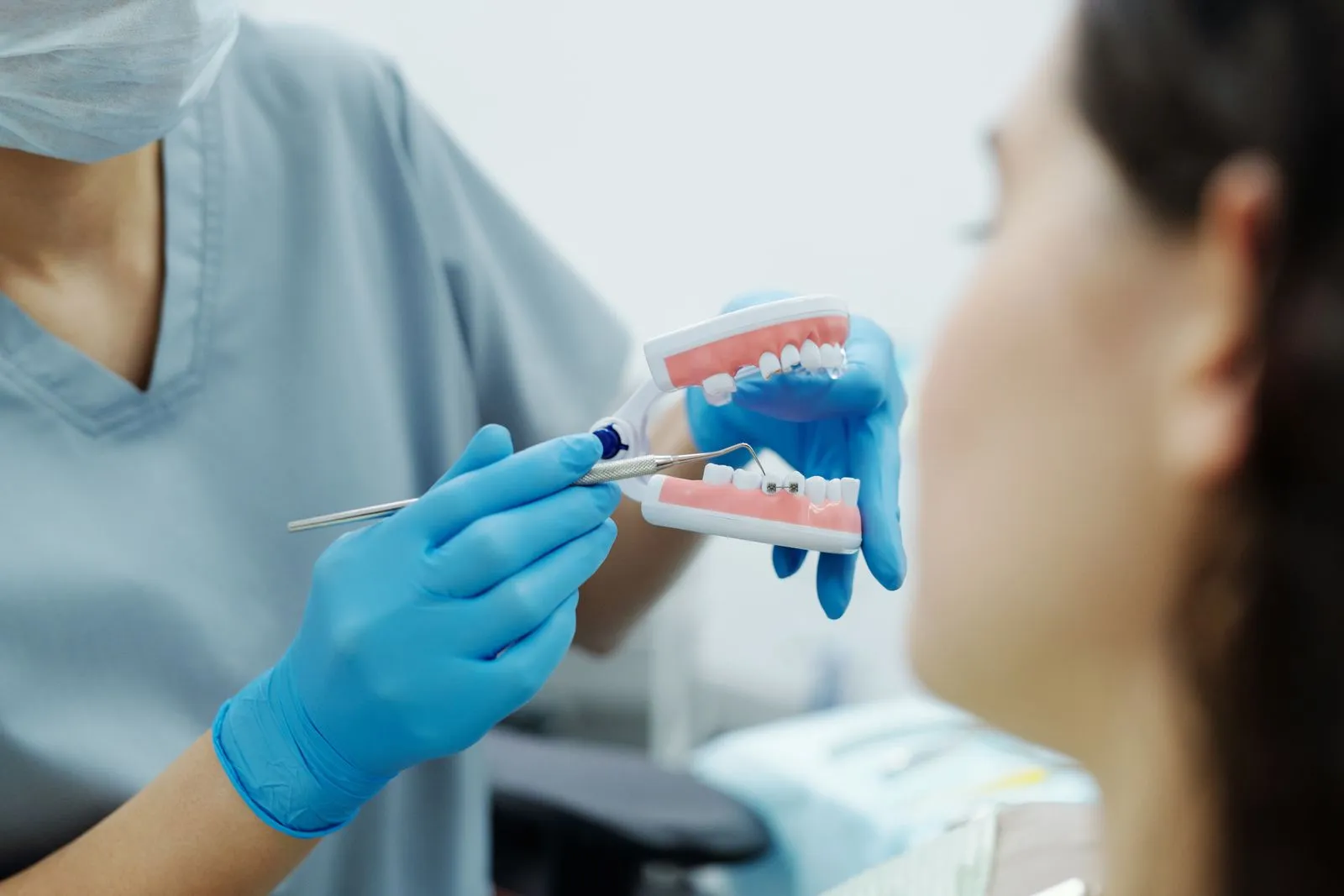 Profesional dental mostrando un modelo de dentadura a una paciente